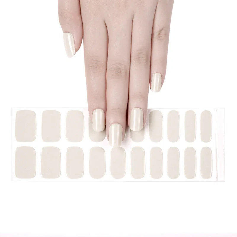 A hand with almond cream colored gel nail stickers applied to the nails.