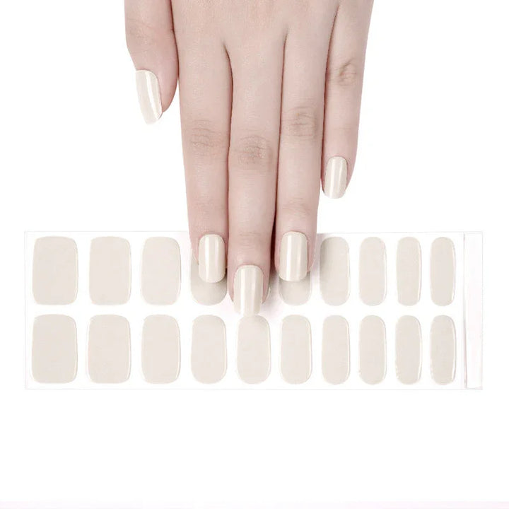 A hand with almond cream colored gel nail stickers applied to the nails.