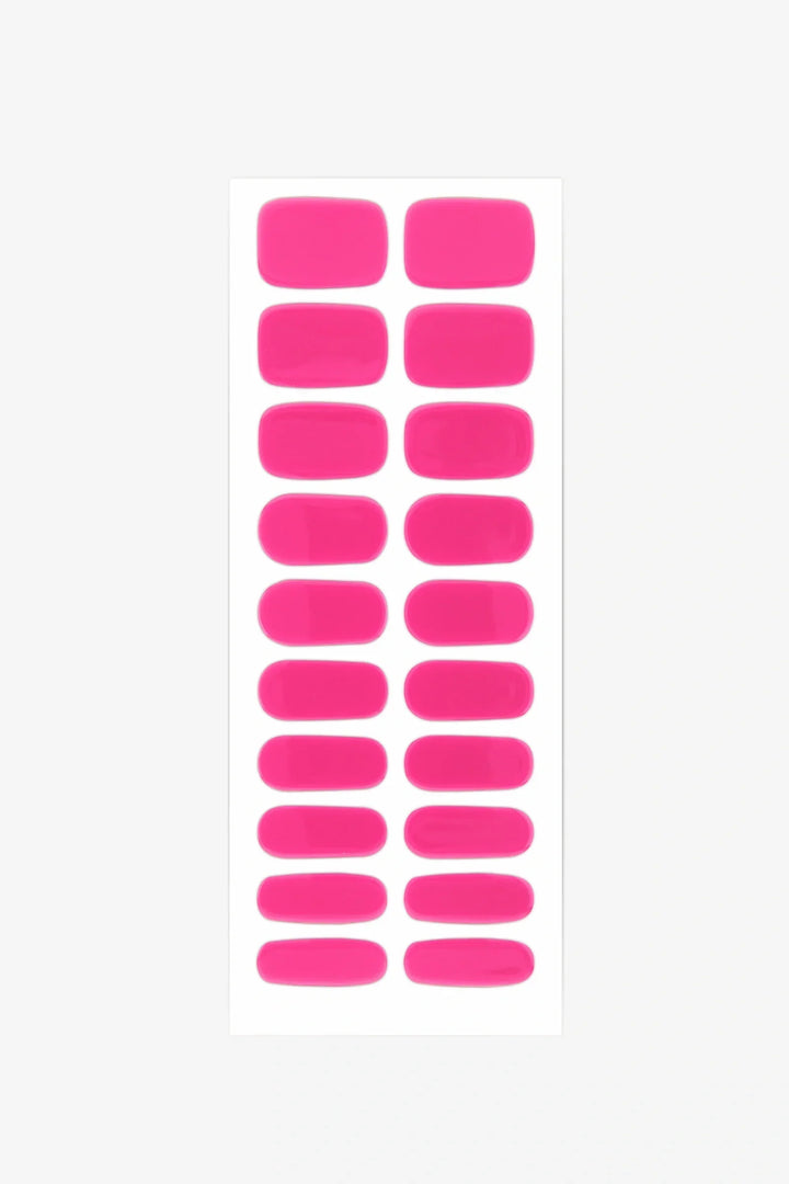 Sheet of bright pink semi-cured gel nail strips with vivid warm tone and glossy surface.