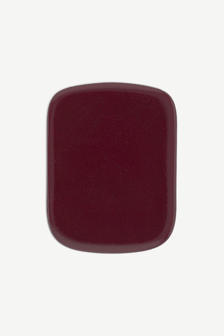 Close-up of a single burgundy red gel toenail wrap showing its glossy, dark red finish.
