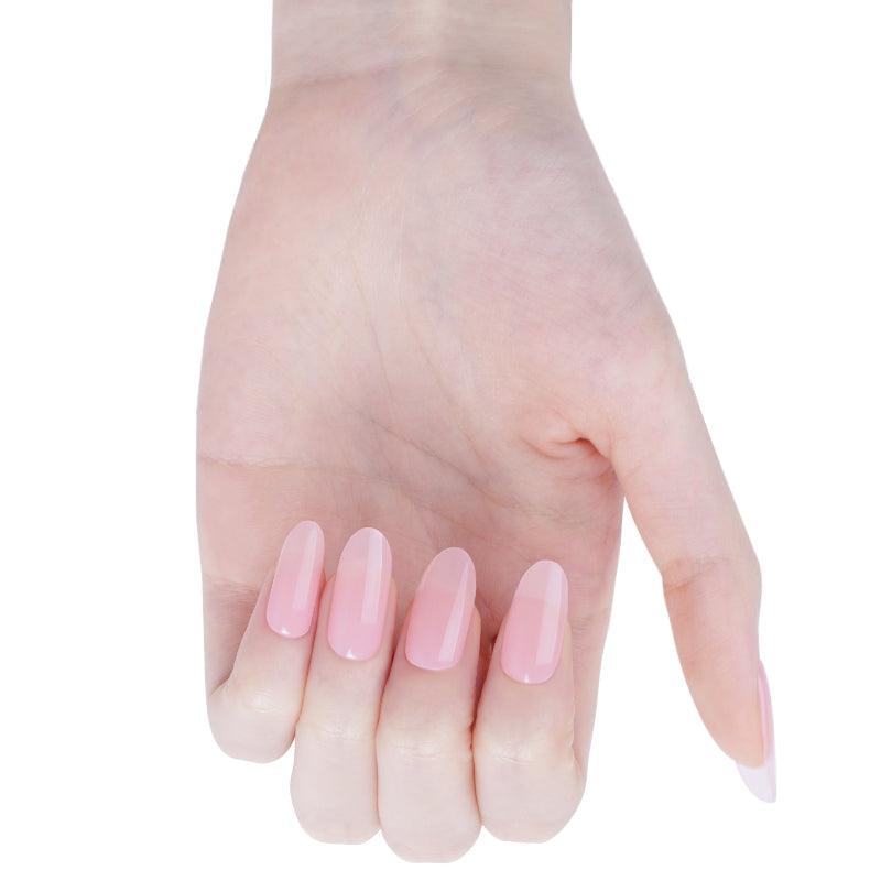 Soft candyfloss pink stick-on gel nails with translucent glossy finish on light skin tone, photographed in neutral lighting.