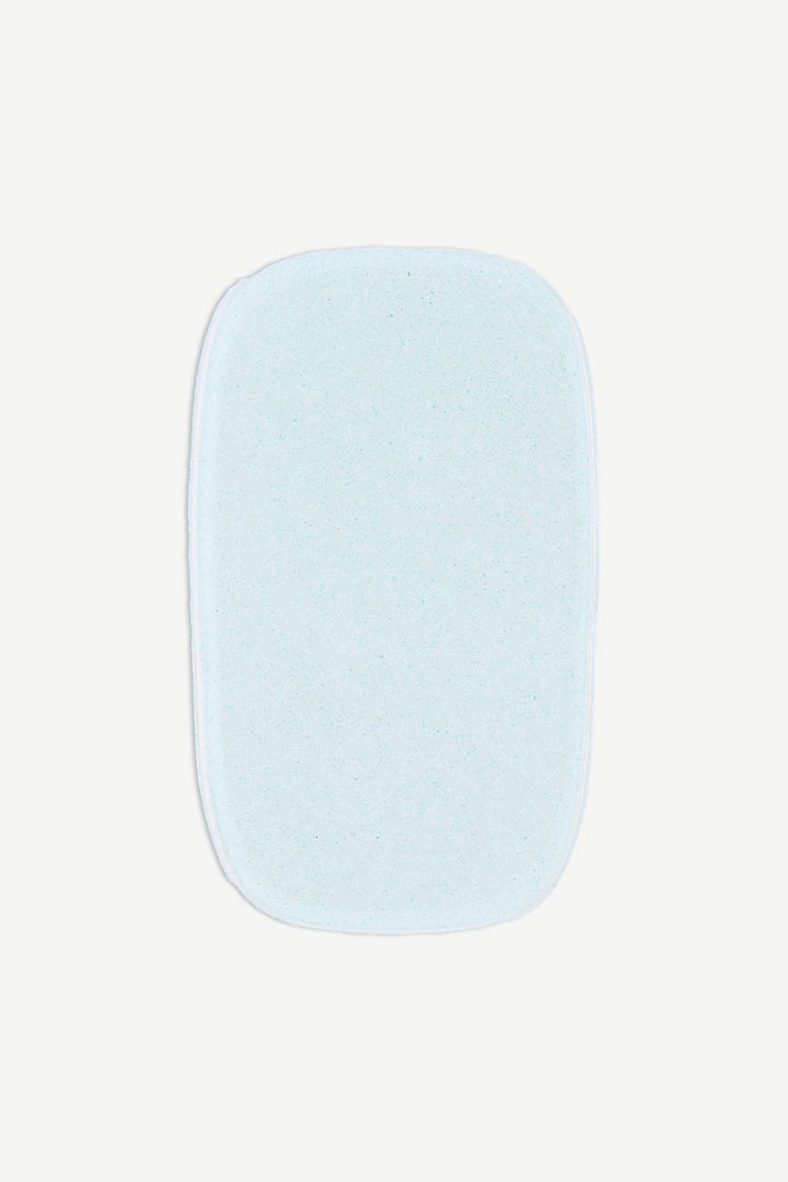 Macro image of an individual chrome mint gel nail strip with metallic pearl finish and translucent aqua undertone.