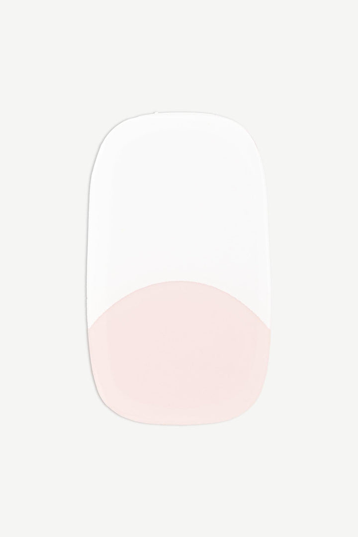 A macro image of a single French tip stick-on gel nail with nude base and clean white edge, shown on white background.