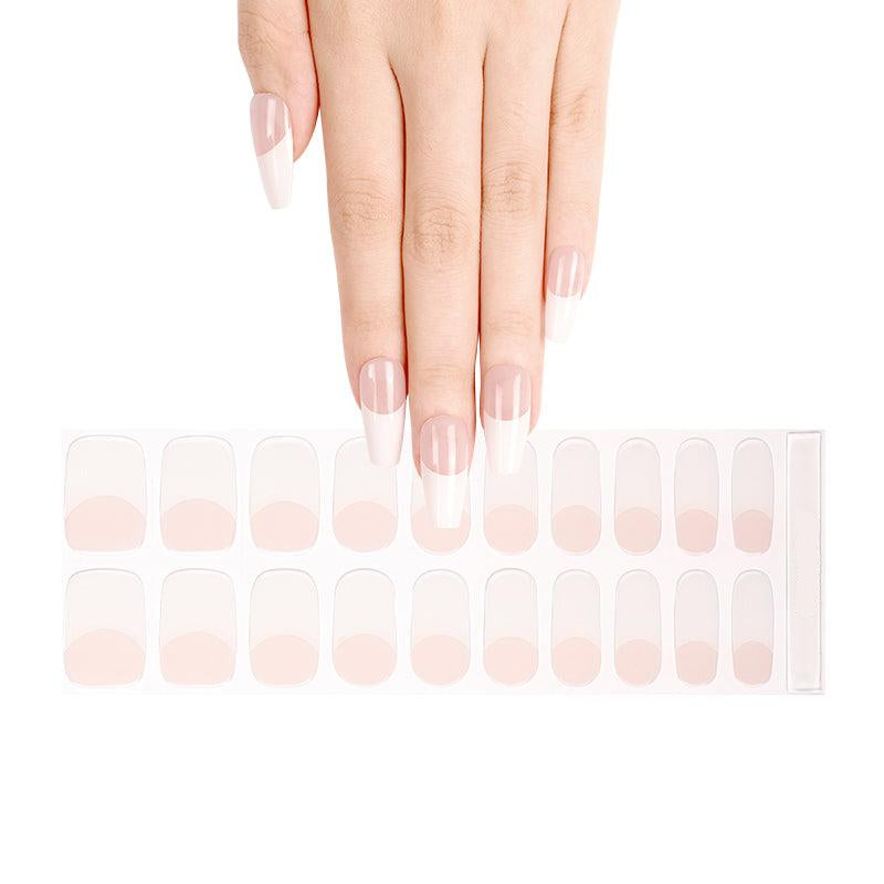 Sheet of French tip gel nail strips with nude base and white tips, shown on light skin tone under neutral studio light.