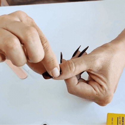 Animated GIF showing a semi-cured gel nail strip being pressed and wrapped onto the nail for quick, salon-quality application.