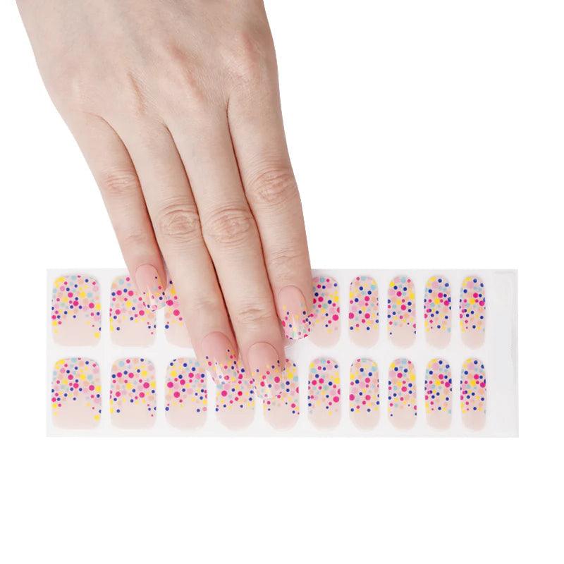 Sheet of nude gel nail strips featuring rainbow polka dots and glossy finish.