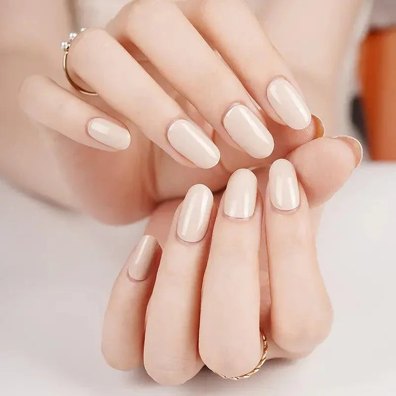 Opaque ivory gel nail wraps with subtle warm undertone and mirror-gloss finish on light skin tone under soft indoor light.