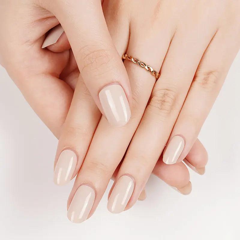 Ivory gel nail wraps with soft cream undertones and glossy high-shine finish on light skin tone, styled with gold chain ring.
