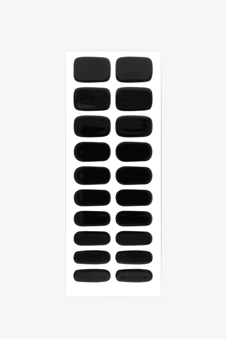 Sheet of matte black semi-cured gel nail strips with solid opaque color and smooth texture