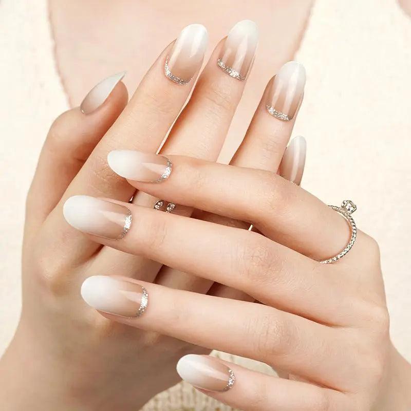 Creamy ombré gel nail wraps fading from soft brown to ivory with metallic silver cuticle cuff on light skin tone, glossy texture in natural light.