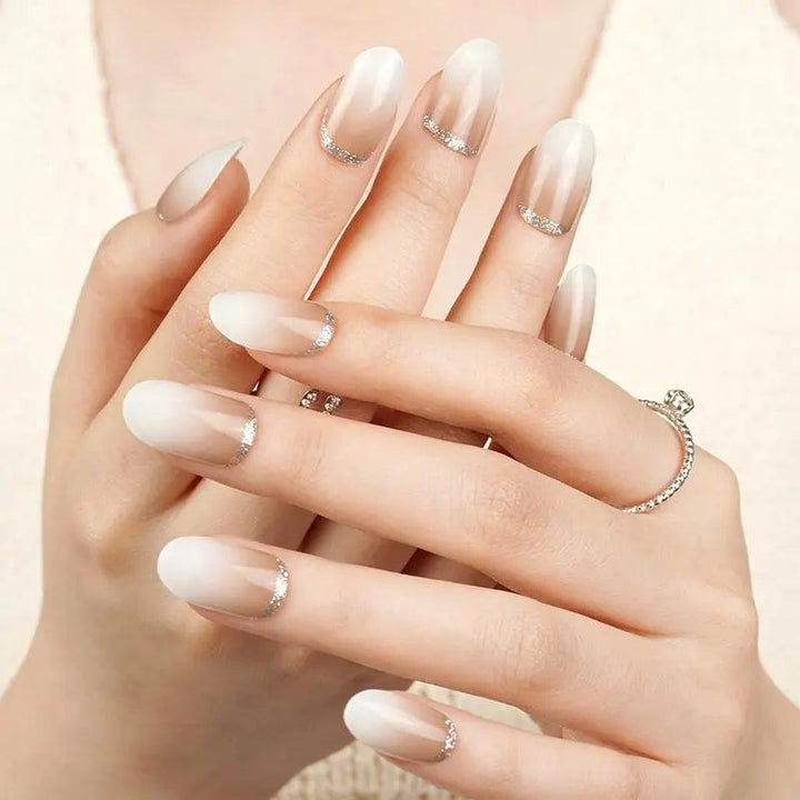 Creamy ombré gel nail wraps fading from soft brown to ivory with metallic silver cuticle cuff on light skin tone, glossy texture in natural light.