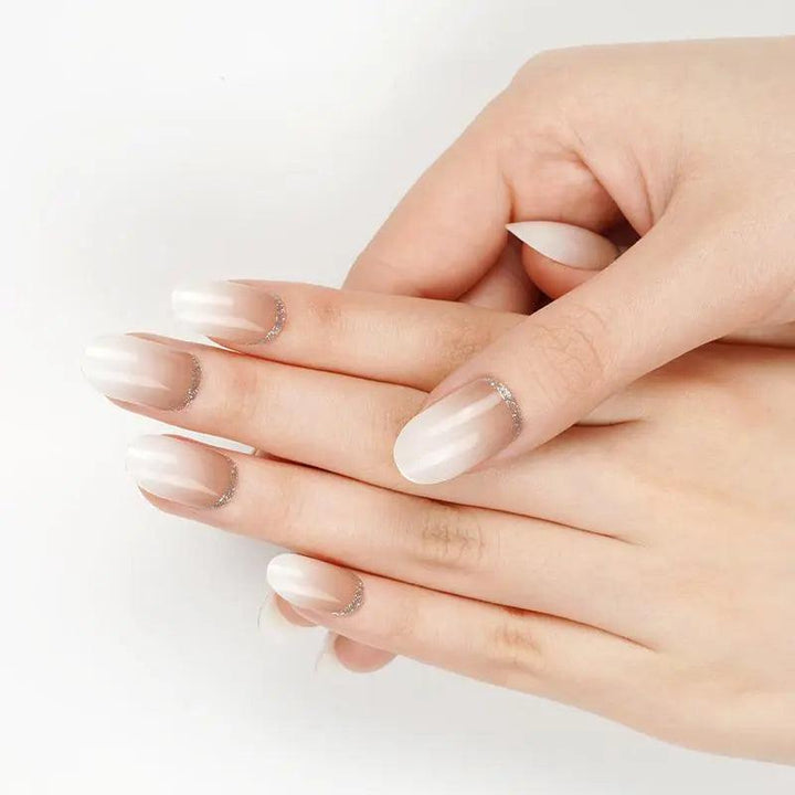 Ivory-brown ombré gel nail wraps with silver cuticle detail on light skin tone, smooth glossy finish in soft daylight.