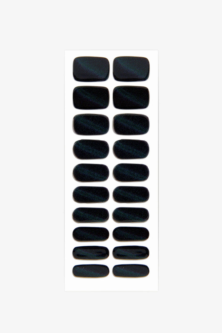 Sheet of slightly translucent black cat-eye gel nail wraps with rainbow shimmer and glossy magnetic finish.