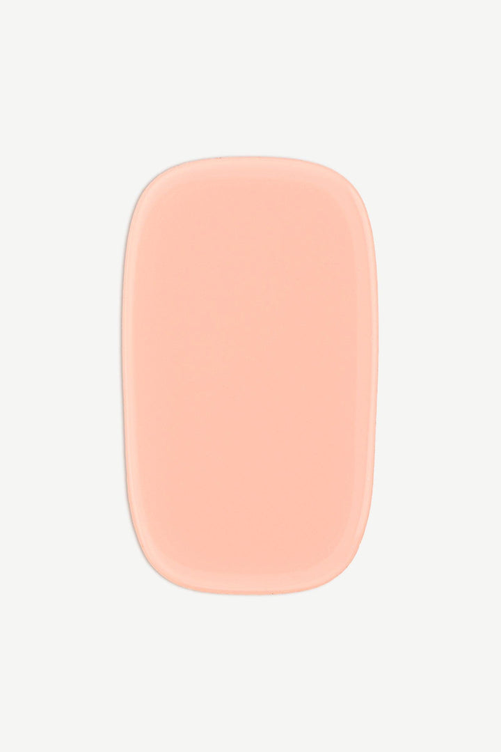 Close-up of a single nude peach stick-on gel nail wrap on a white background.