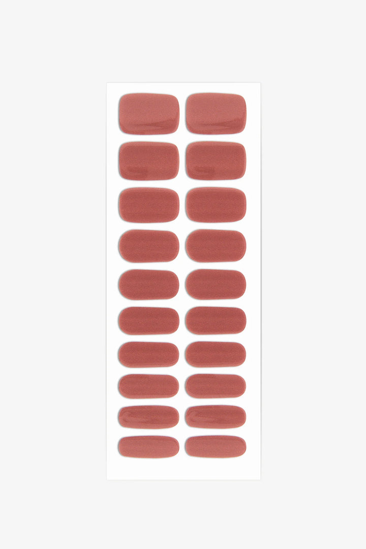 Sheet of semi-cured gel nail wraps in rust-red tones with a magnetic shimmer and smooth, high-gloss surface.