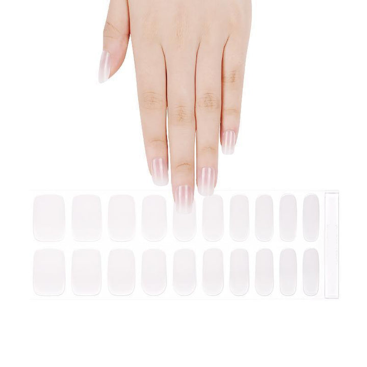 Sheet of semi-transparent nude gel nail strips with ombré gradient arranged on white background.