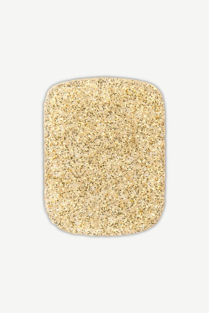 Close-up of gold glitter gel toenail wrap with dense shimmer and smooth glossy surface.