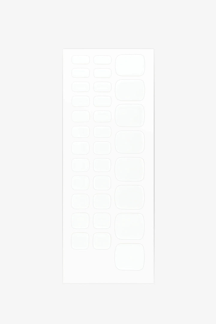 Sheet of solid white semi-cured gel toenail wraps with smooth glossy finish and full-coverage design.