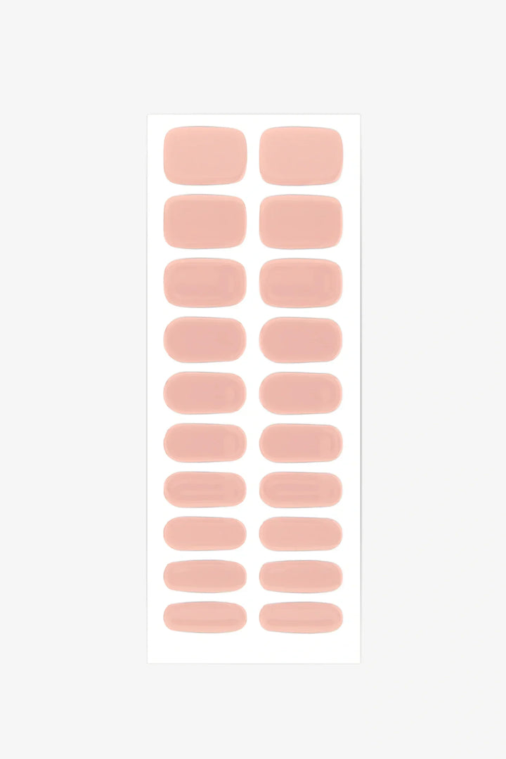 Sheet of soft peach semi-cured gel nail strips with nude coral tones and glossy finish.