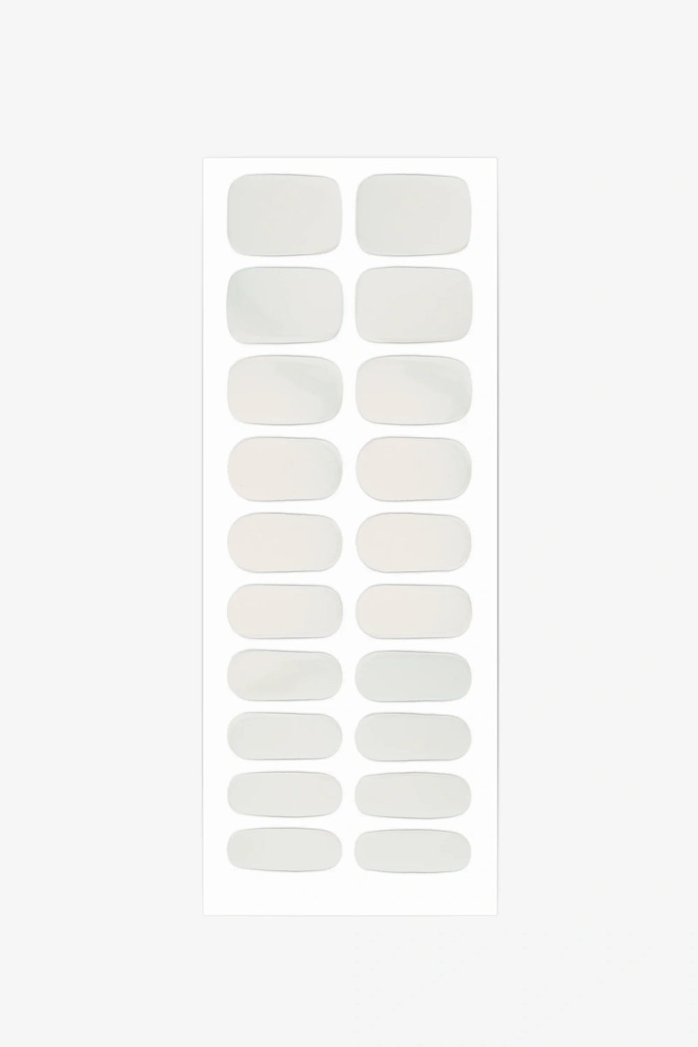 Sheet of semi-cured gel nail wraps featuring milky nude-beige shades that shift between ivory and warm peach.