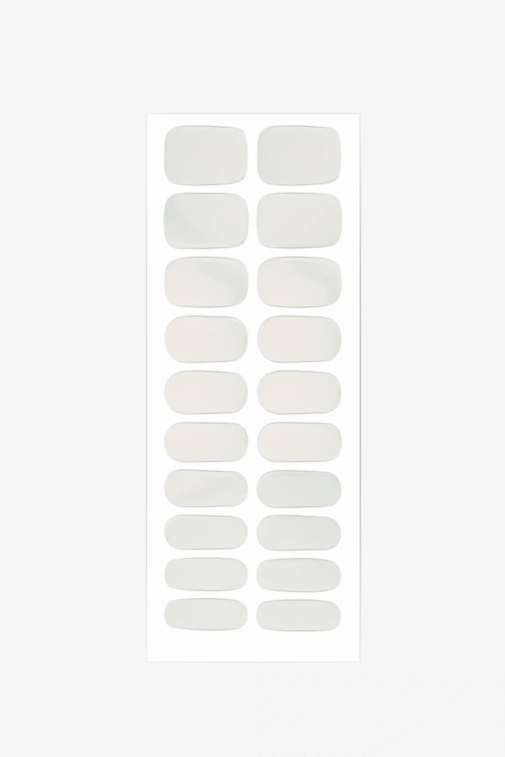 Sheet of semi-cured gel nail wraps featuring milky nude-beige shades that shift between ivory and warm peach.