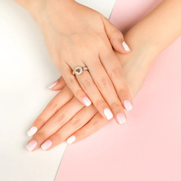 Hands with Baby Boomer gel nail wraps with a milky white and blush pink ombre in a soft, glossy gradient finish, shown against a pink and white background.