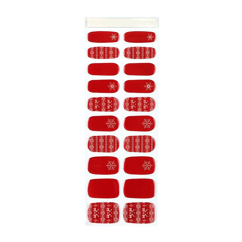Sheet of red semi-cured gel nail strips with glossy finish and white holiday snowflake patterns.