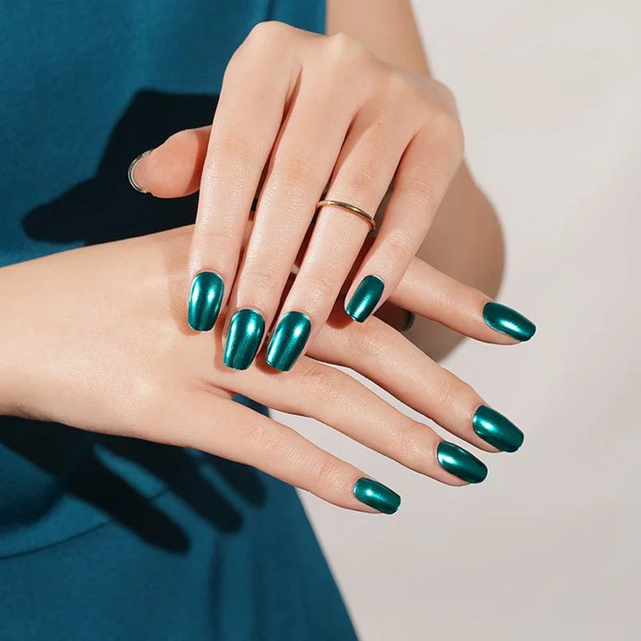 Cobalt semi-cured gel nail stickers in a deep metallic blue, photographed under soft studio lighting on light skin with a simple gold ring and a teal-blue top.