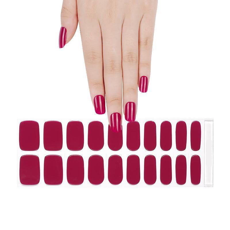 Cranberry red semi-cured gel nail strips with glossy finish on light skin tone, photographed under bright neutral light.