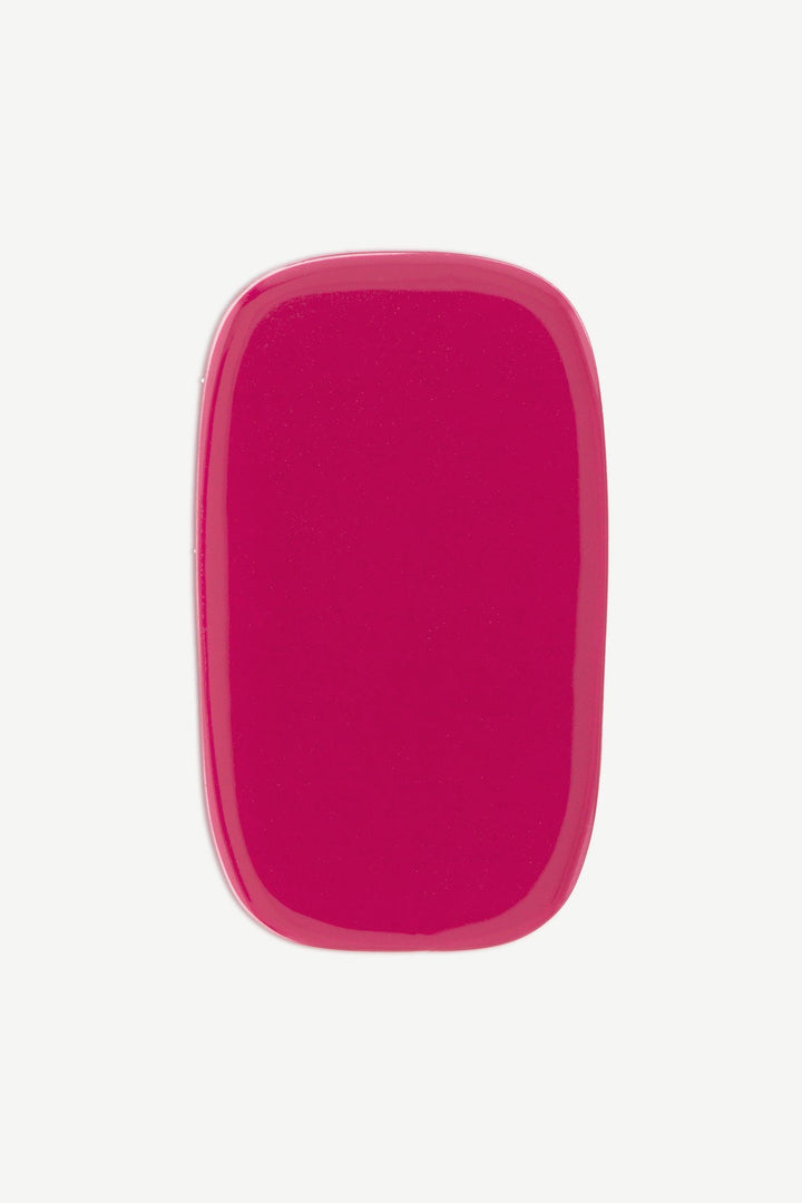 A macro image of a cranberry red stick-on gel nail with smooth glossy surface, shown on white background.

