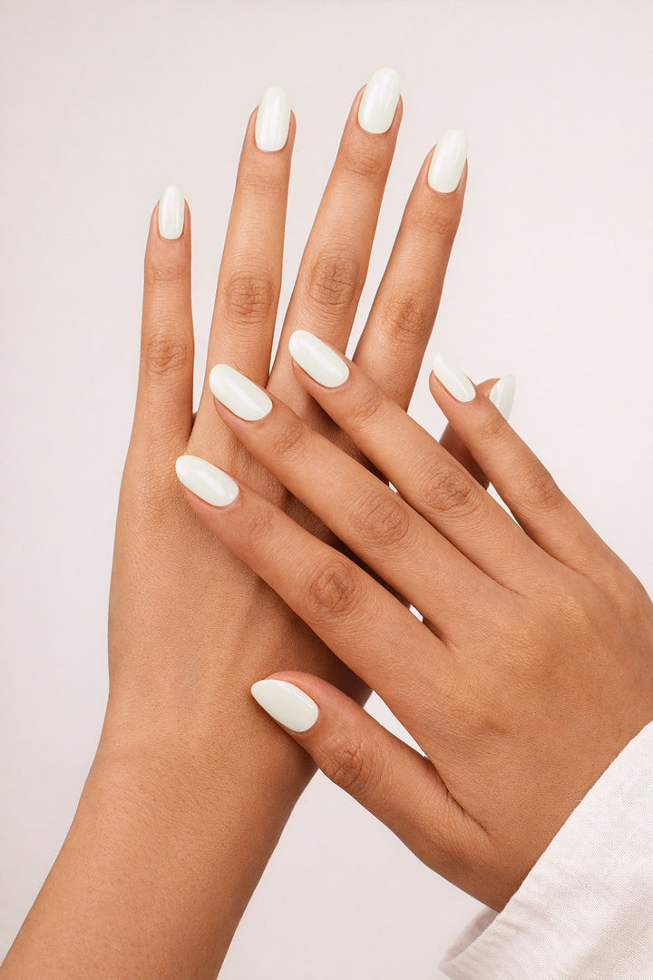 Dairy Queen semi-cured gel nail stickers with a soft milk-white, opaque high-gloss finish on medium-tan skin, photographed under soft studio lighting with a clean white long-sleeve outfit.