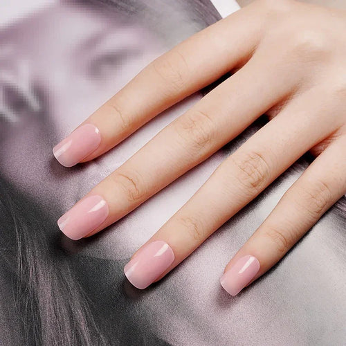 Hands with Dawn gel nail wraps in semi-translucent blush pink, glowing with a soft rose tint and dewy, high-shine finish, shown against smooth fabric.