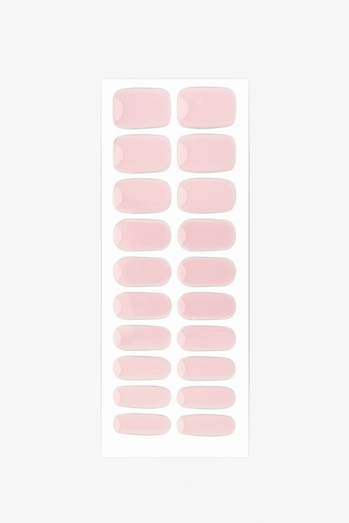 Sheet of Gelly French Moon semi-cured gel nail wraps showing milky pink strips with clean cuticle crescents for minimalist reverse-French manicures.