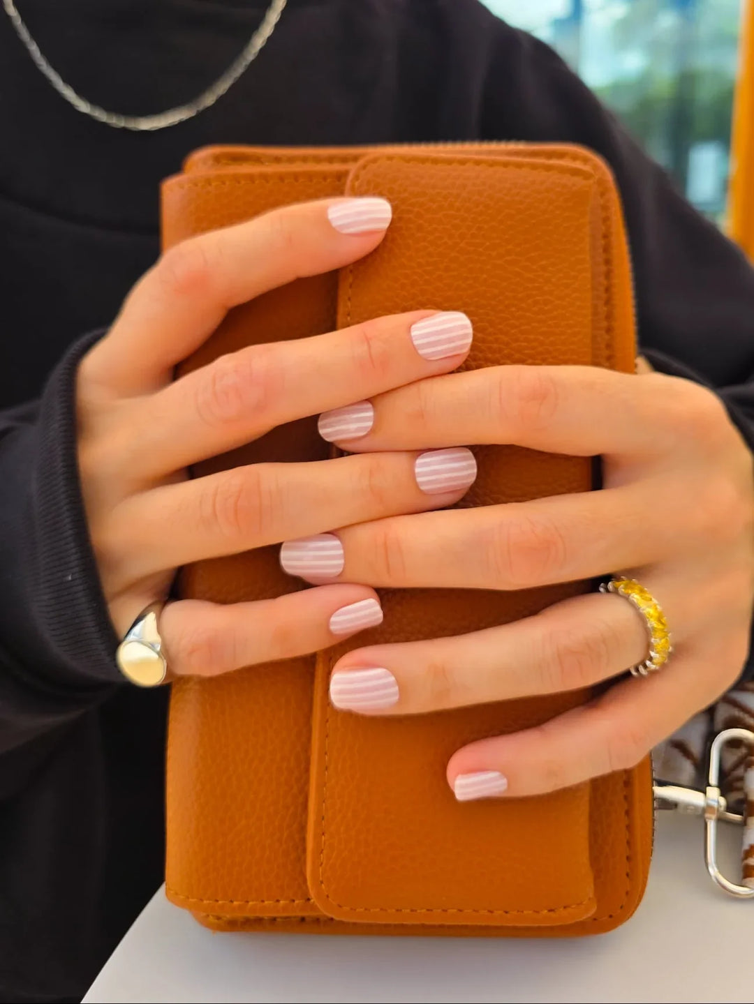 Person holding a brown wallet with a blurred background