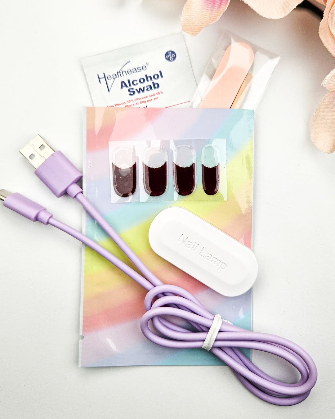 Sensitivity Test Kit from Gelly showing four sample gel nail strips, mini USB UV lamp with cable, alcohol prep pad, wooden cuticle stick and mini nail file.