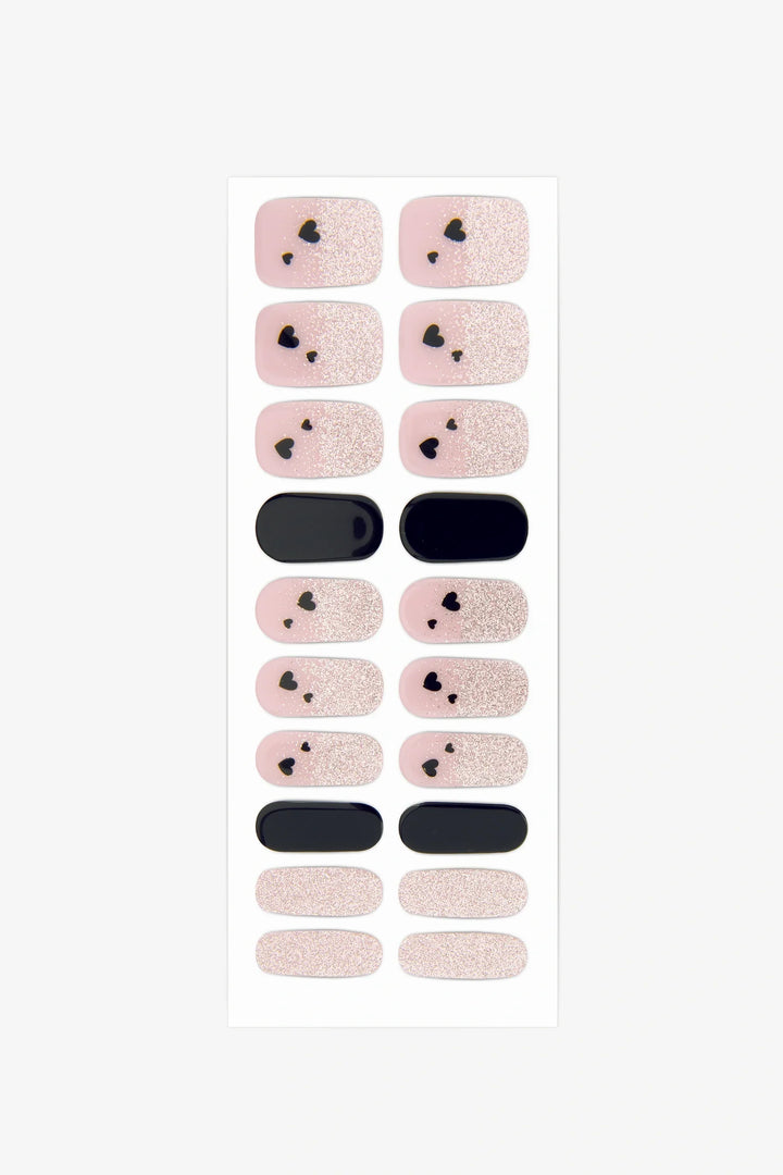 Full sheet of It Girl gel nail stickers featuring pink-nude and black designs with heart details and shimmer accents, displayed in various sizes on a white background.