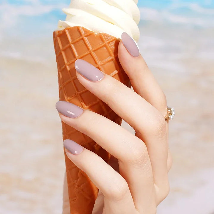 Semi-cured gel nail wraps in light mauve with a smooth, glossy finish, shown on fair skin with delicate gold jewelry.