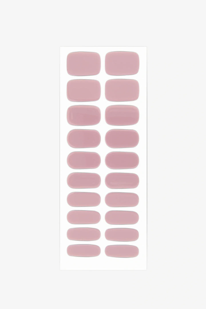 Sheet of semi-cured gel nail wraps in muted mauve-pink shades with a creamy, high-gloss surface.