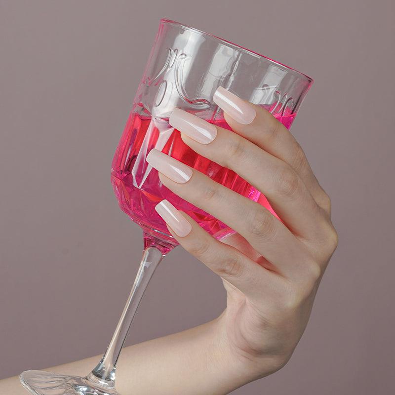 Natural beige gel nail wraps with glossy finish on light skin tone.