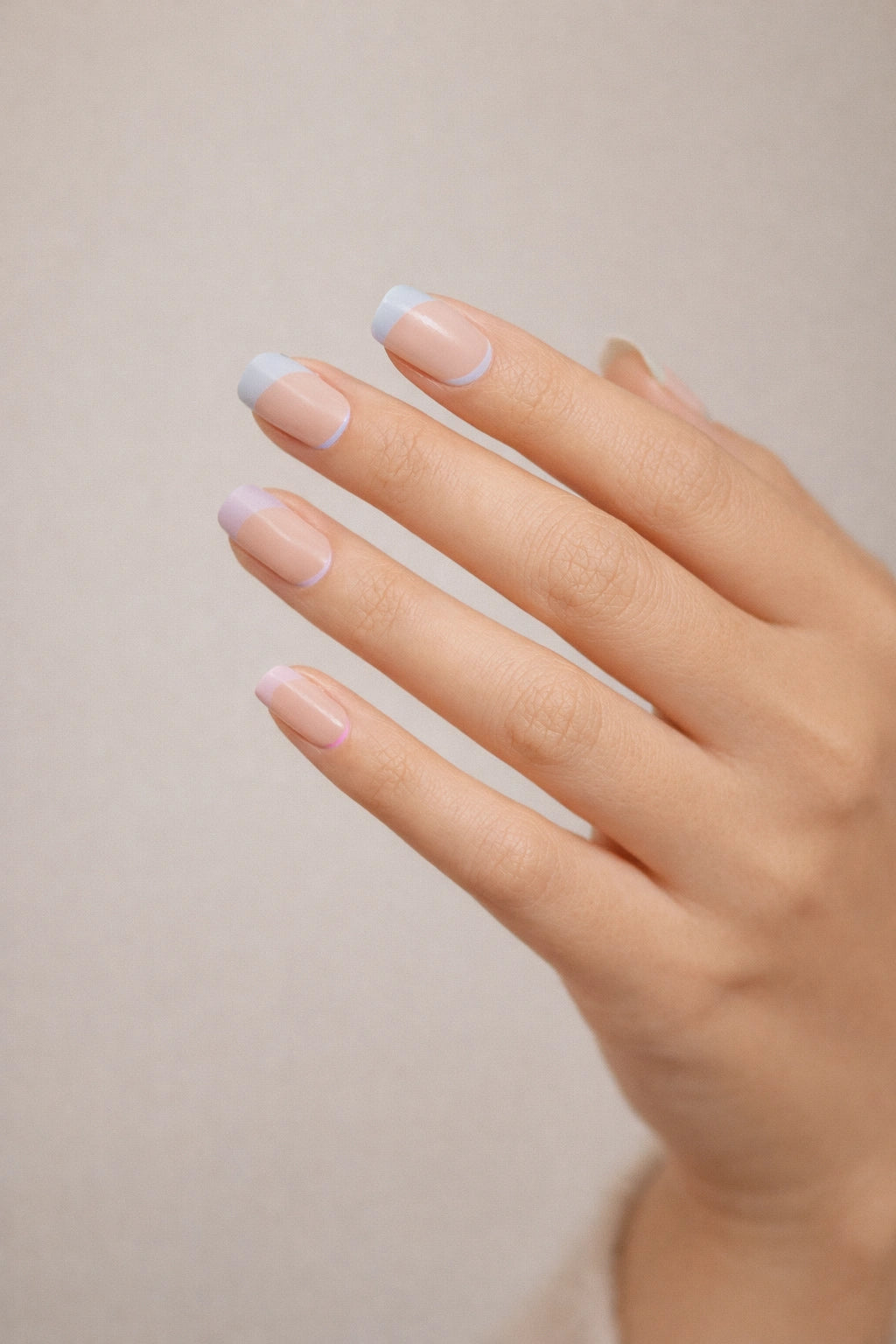 Pastel Rainbow semi-cured gel nail stickers, shown on light skin with sheer nude bases and soft pastel French tips in pink, blue, yellow, green, and lilac, photographed under soft studio lighting against a neutral background.