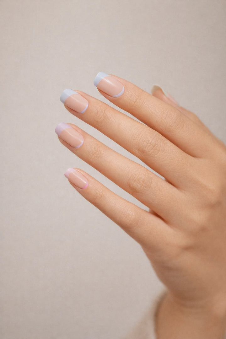Pastel Rainbow semi-cured gel nail stickers, shown on light skin with sheer nude bases and soft pastel French tips in pink, blue, yellow, green, and lilac, photographed under soft studio lighting against a neutral background.