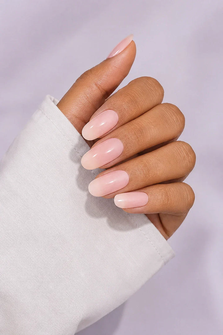 Peach Glaze UV-free gel nail wraps in a very light neutral peach with a soft milky appearance and a glossy finish, shown on medium skin.