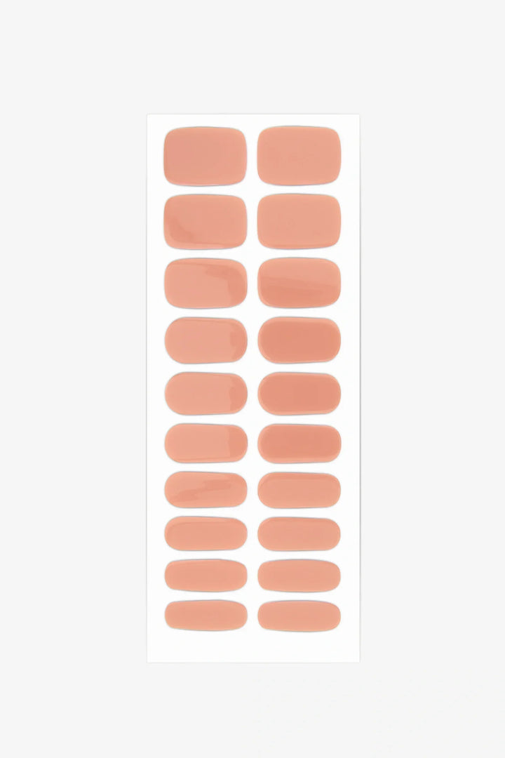 Sheet of semi-cured gel nail wraps in soft peach tones with a creamy, high-gloss surface.
