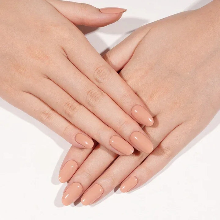 Semi-cured gel nail wraps in peach with a smooth, glossy finish, shown on light skin under soft natural light.