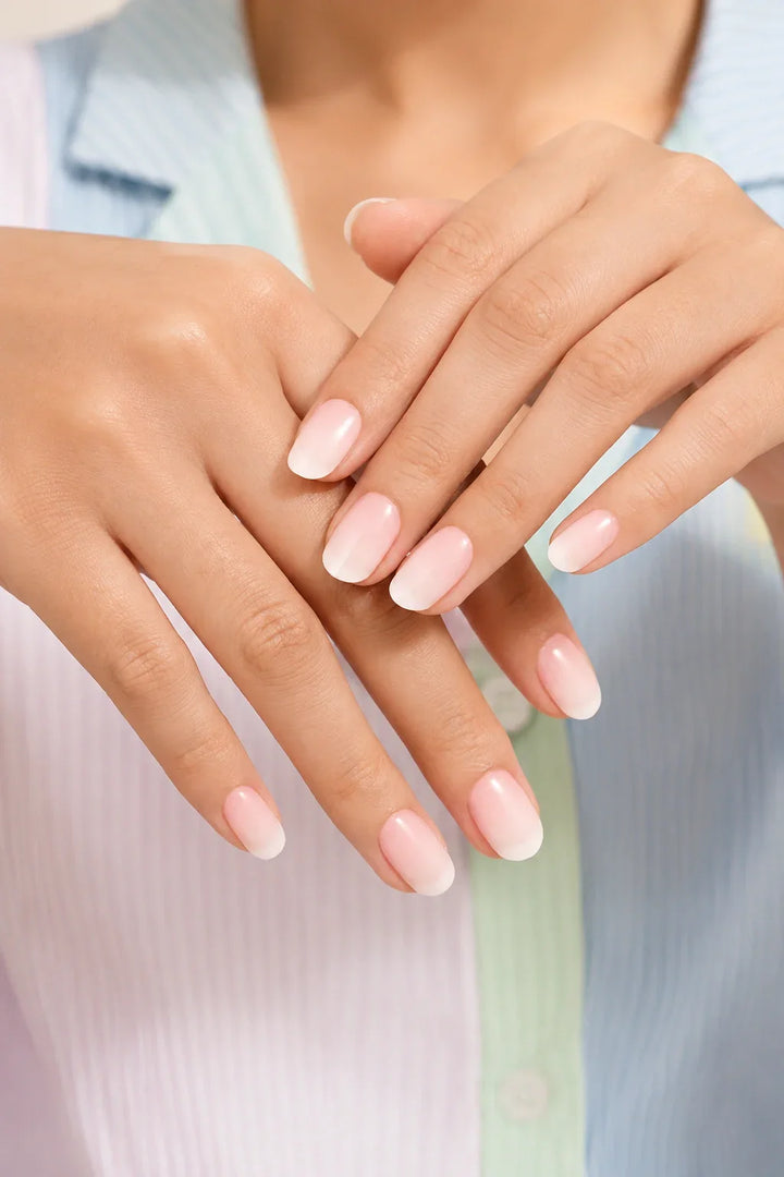 Pienk Melkie UV-free gel nail wraps in a soft pink-to-white gradient with a slightly milky appearance and a glossy finish, shown on light skin.