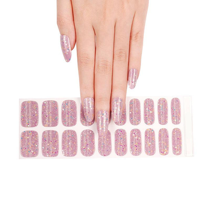Hand holding a sheet of pink glitter gel nail stickers with holographic and glow-in-the-dark effects.