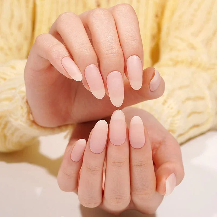 Semi-cured gel nail wraps in soft nude-pink with a matte surface, shown on two hands under natural lighting.