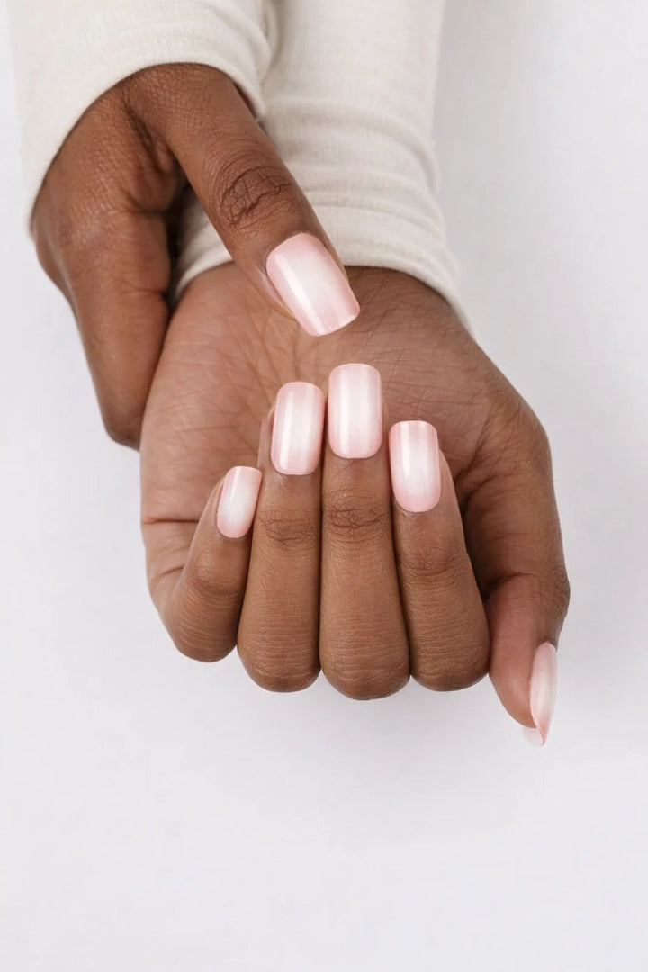 Pink ombre semi-cured gel nail wraps in neutral, blush pink with a subtle milky white ombré fade and glossy finish, shown on dark skin against a clean white background.