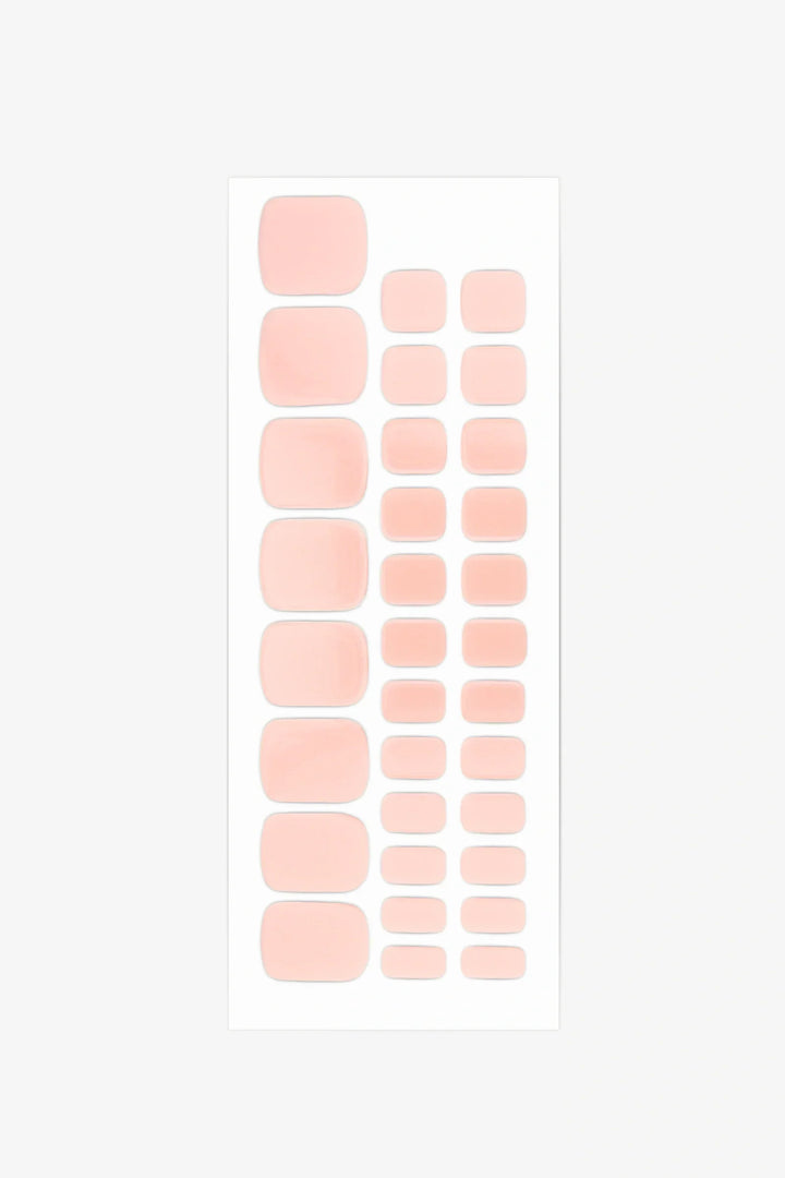 Full sheet of blush pink gel toenail strips in varying sizes displayed on a white background.
