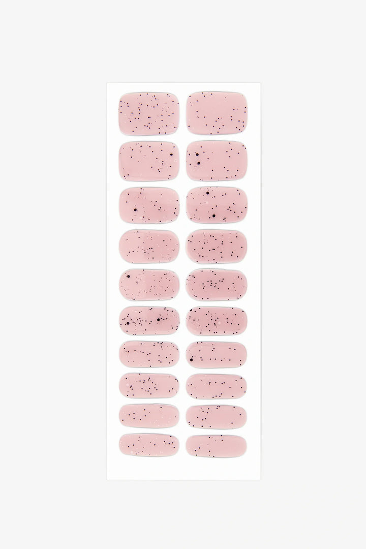 Full sheet of Pink Speckled Eggs gel nail wraps in a sheer pink shade with fine black speckles, arranged in various sizes on a white background.